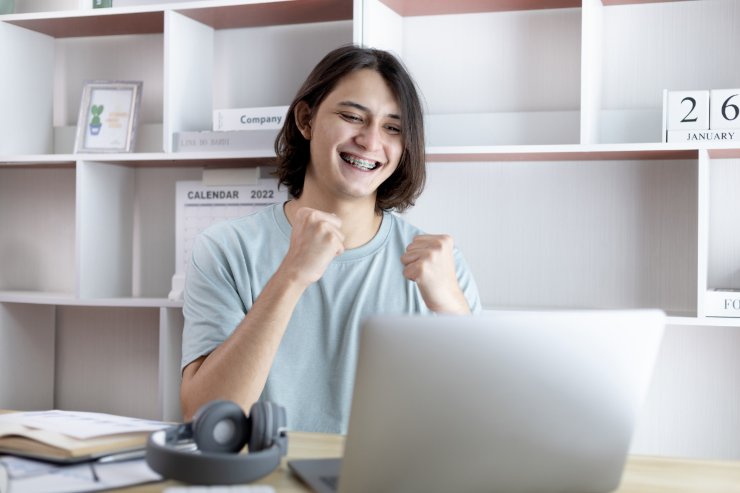 ragazza festeggia di fronte a pc
